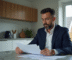 Homme en costume bleu examinant des documents financiers