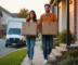 Jeune couple portant des cartons lors d'un déménagement matinal