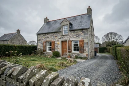Maison en pierre bretonne à vendre dans le Finistère 29, façade en granite avec volets blancs et jardin négligé, ambiance mélancolique d'une vente urgente cause divorce